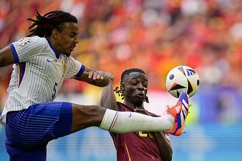 Jules Kounde and Jeremy Doku fight for the ball